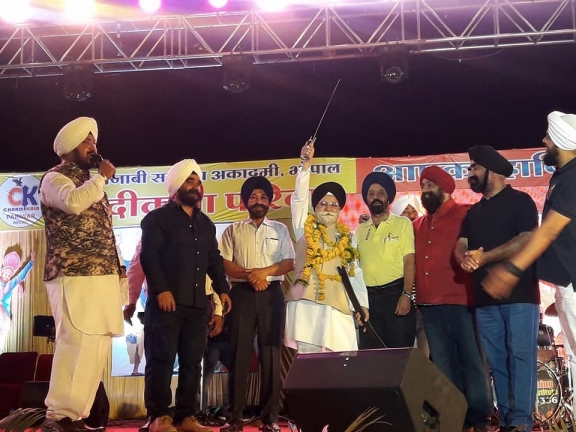 ਰਵਿੰਦਰ ਸਿੰਘ ਕਲਸੀ, ਹਰਪ੍ਰੀਤ ਬਖਸ਼ੀ, ਅਜੀਤ ਸਿੰਘ ਨਾਰੰਗ, ਰਣਵੀਰ ਸਿੰਘ ਛਾਬੜਾ ਉਰਫ ਬੌਬੀ ਛਾਬੜਾ, ਜਸਵੰਤ ਸਿੰਘ ਜੱਸਾ ਰਾਸ਼ਟਰੀ ਸਿੱਖ ਸੰਗਤ ਦੇ ਰਾਸ਼ਟਰੀ ਪ੍ਰਧਾਨ ਗੁਰਚਰਨ ਸਿੰਘ ਗਿੱਲ ਨੂੰ ਕਿਰਪਾਨ ਭੇਟ ਕਰਦੇ ਹੋਏ