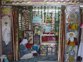 Image of Chaman Lal on Mandir Wall with images of Sikh Gurus